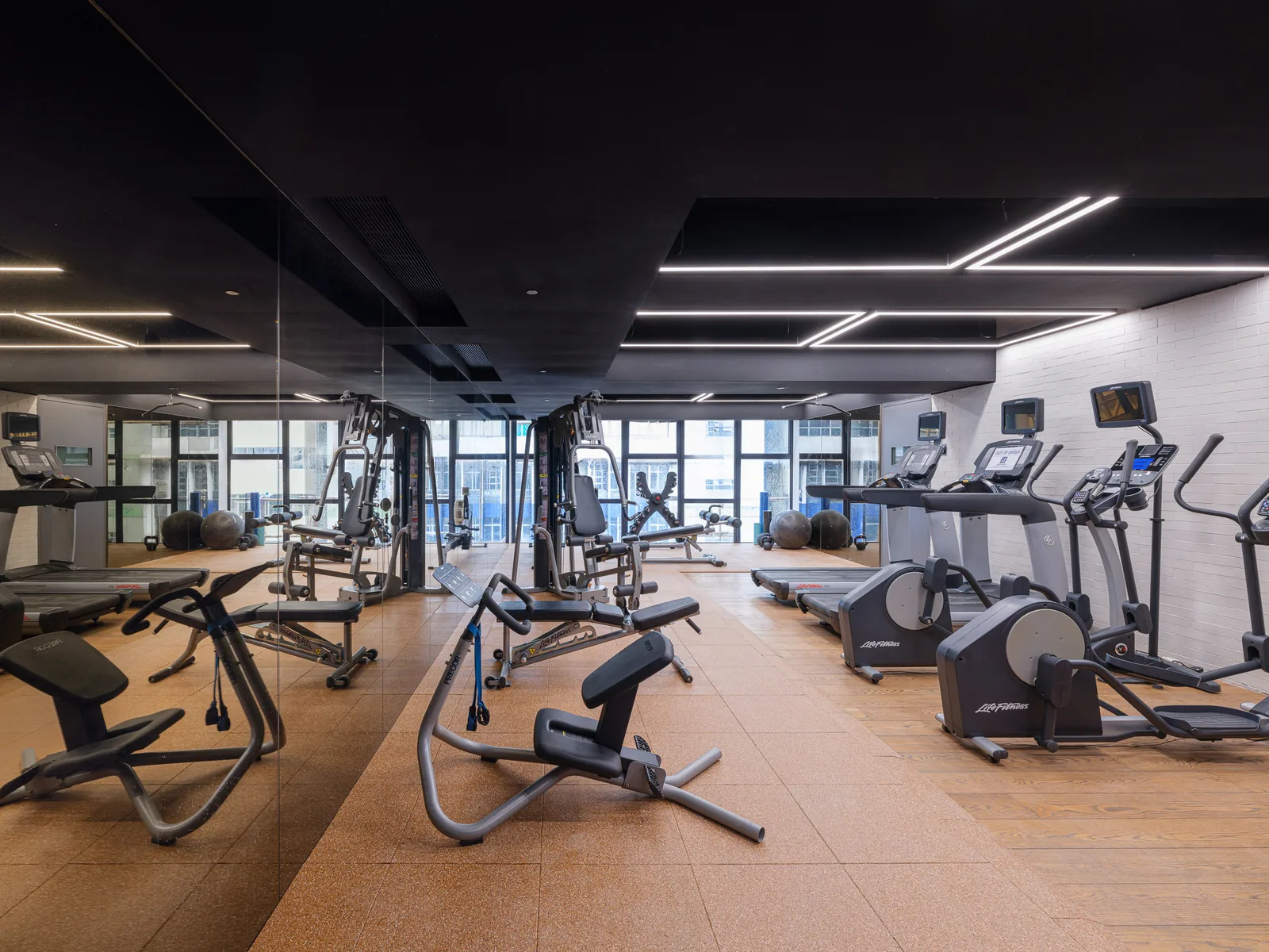 Resident gym at Stride Wong Chuk Hang with treadmills, free weights and a mirrored wall