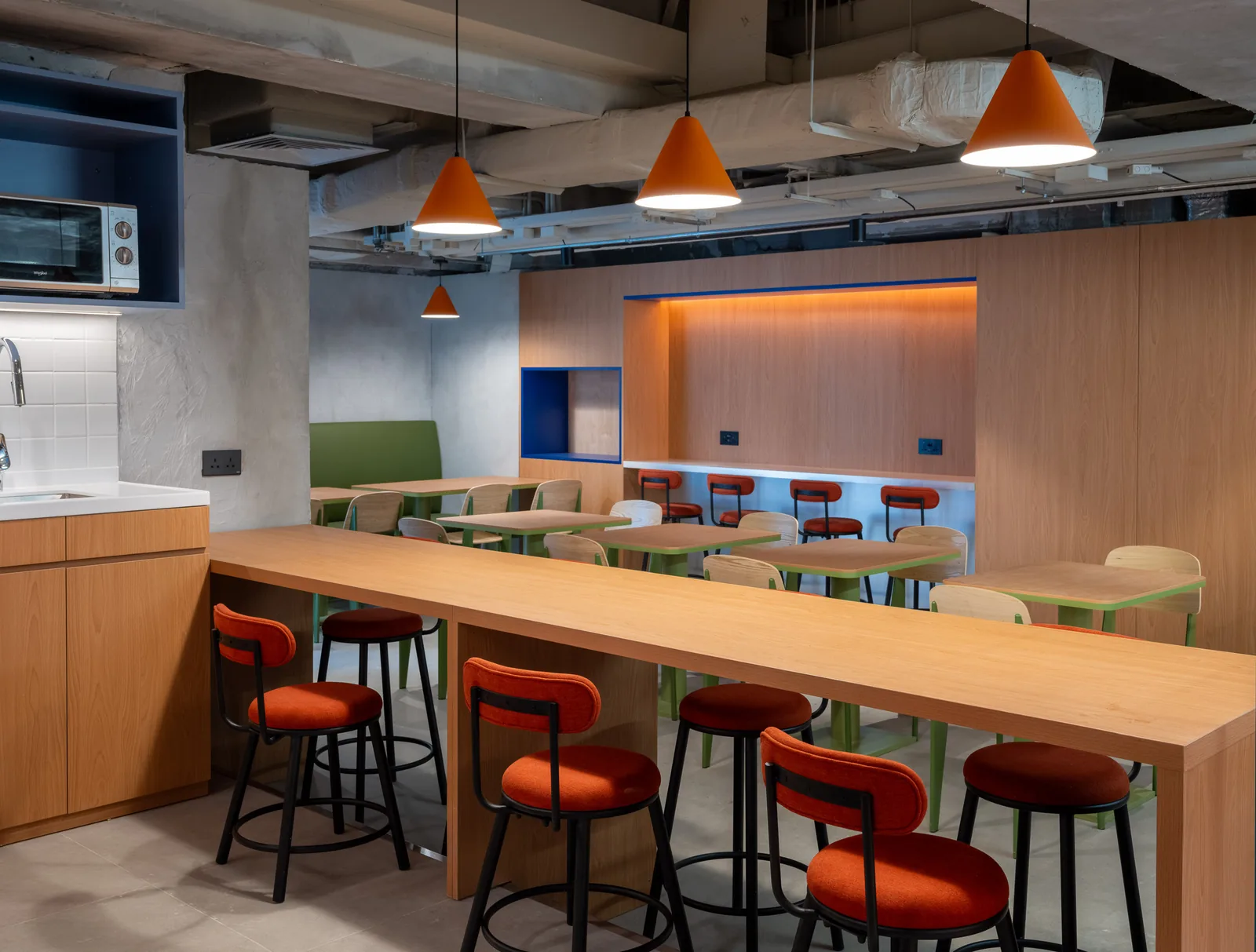Shared kitchen and dining area at Stride Wong Chuk Hang with a long oak breakfast bar