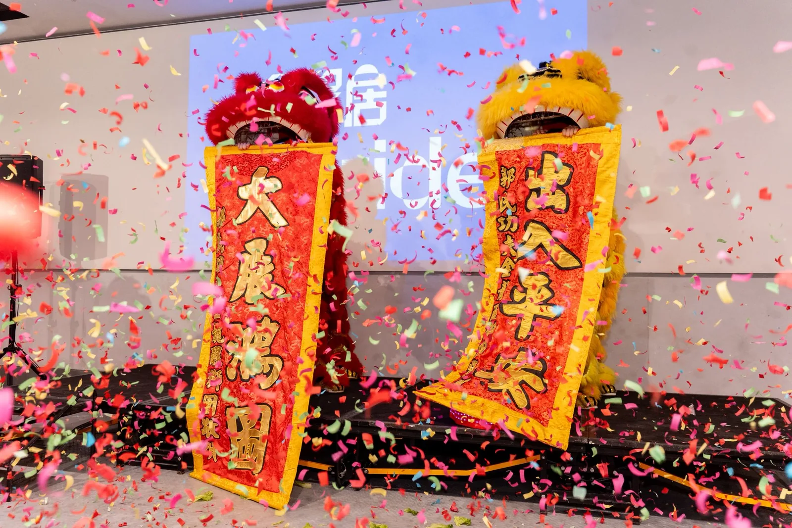 Lion dancers unveiling celebratory scrolls in a shower of confetti at the Stride Wong Chuk Hang opening